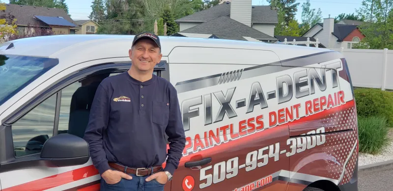 Alex Hivrenko standing beside the FixADent mobile service van