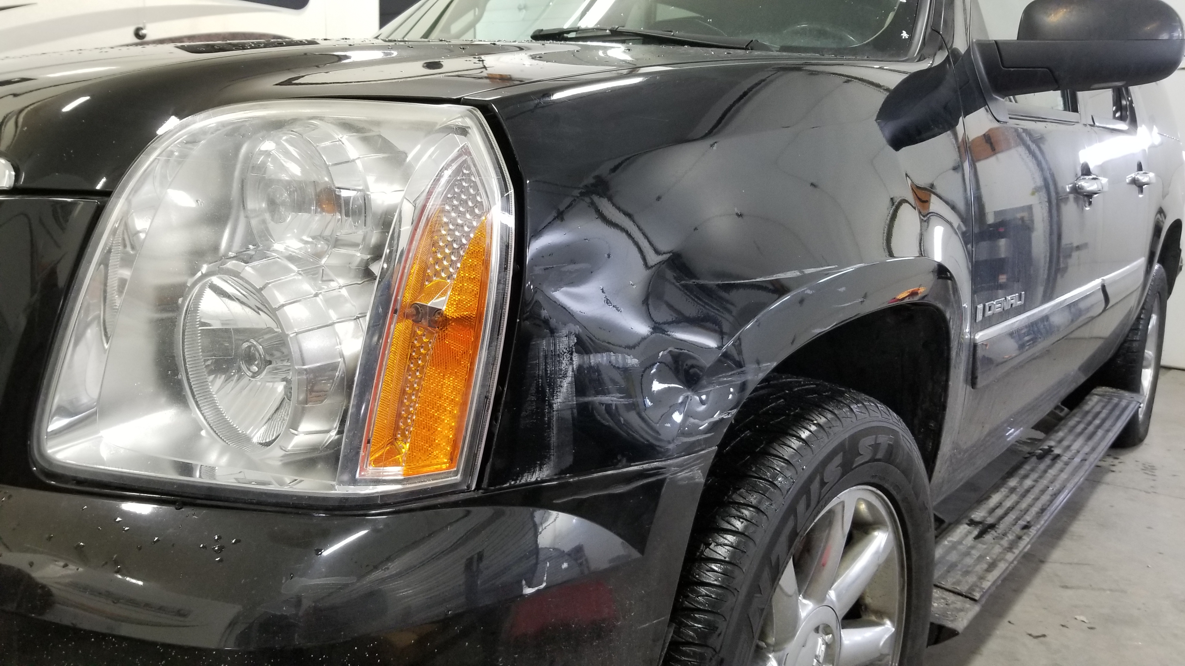 Black SUV front fender before paintless dent repair