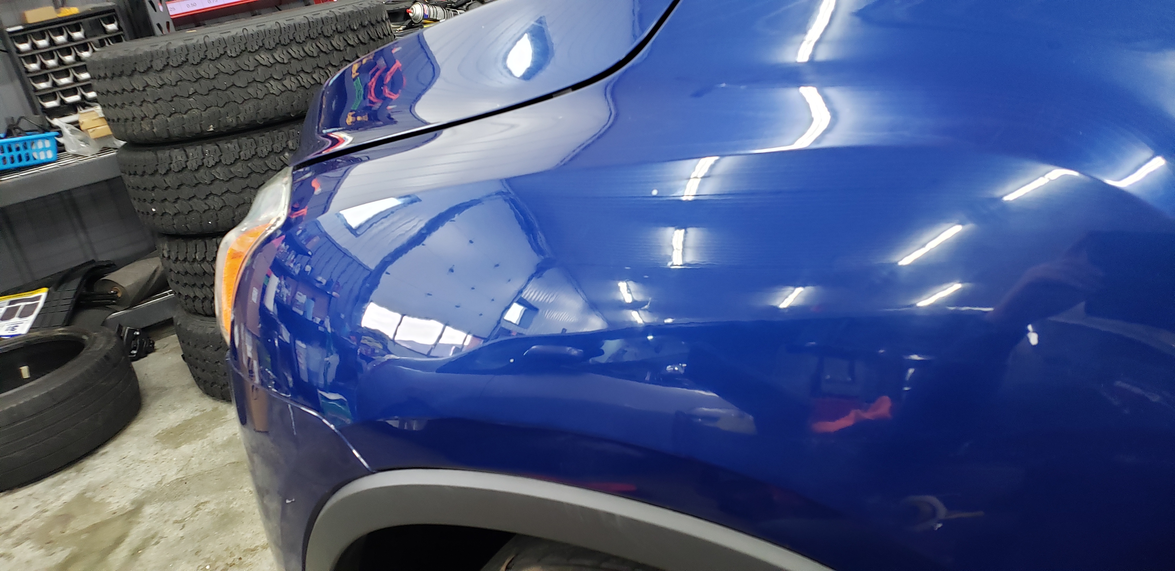 Blue vehicle fender after paintless dent repair
