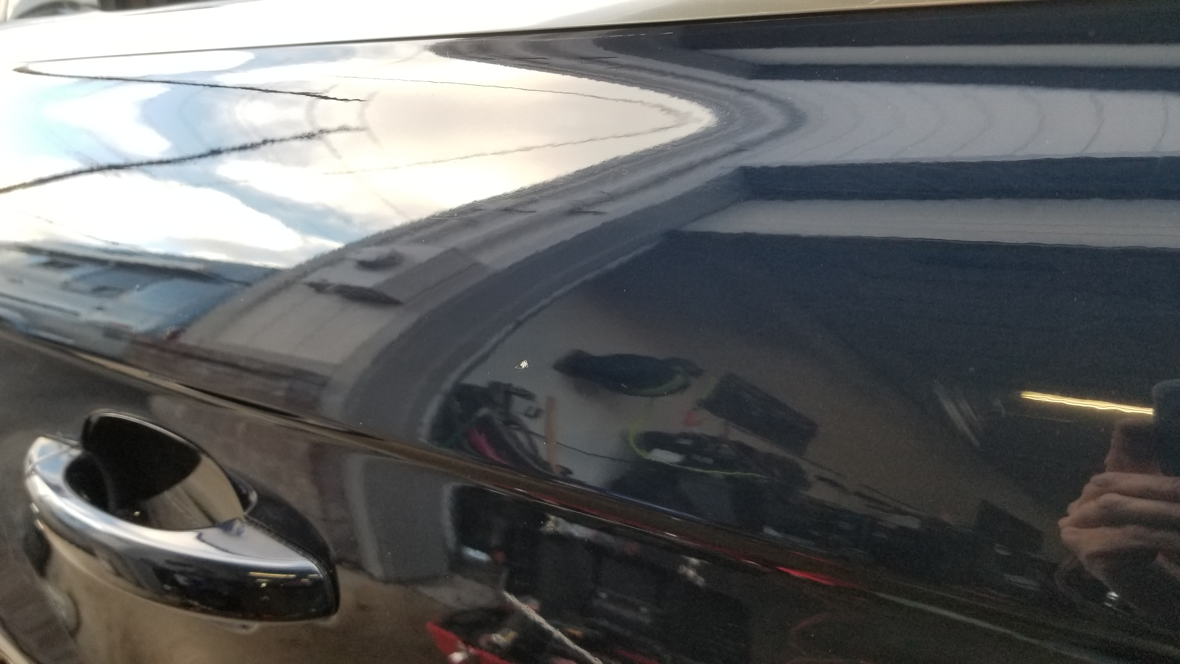 Dark vehicle door after paintless dent repair