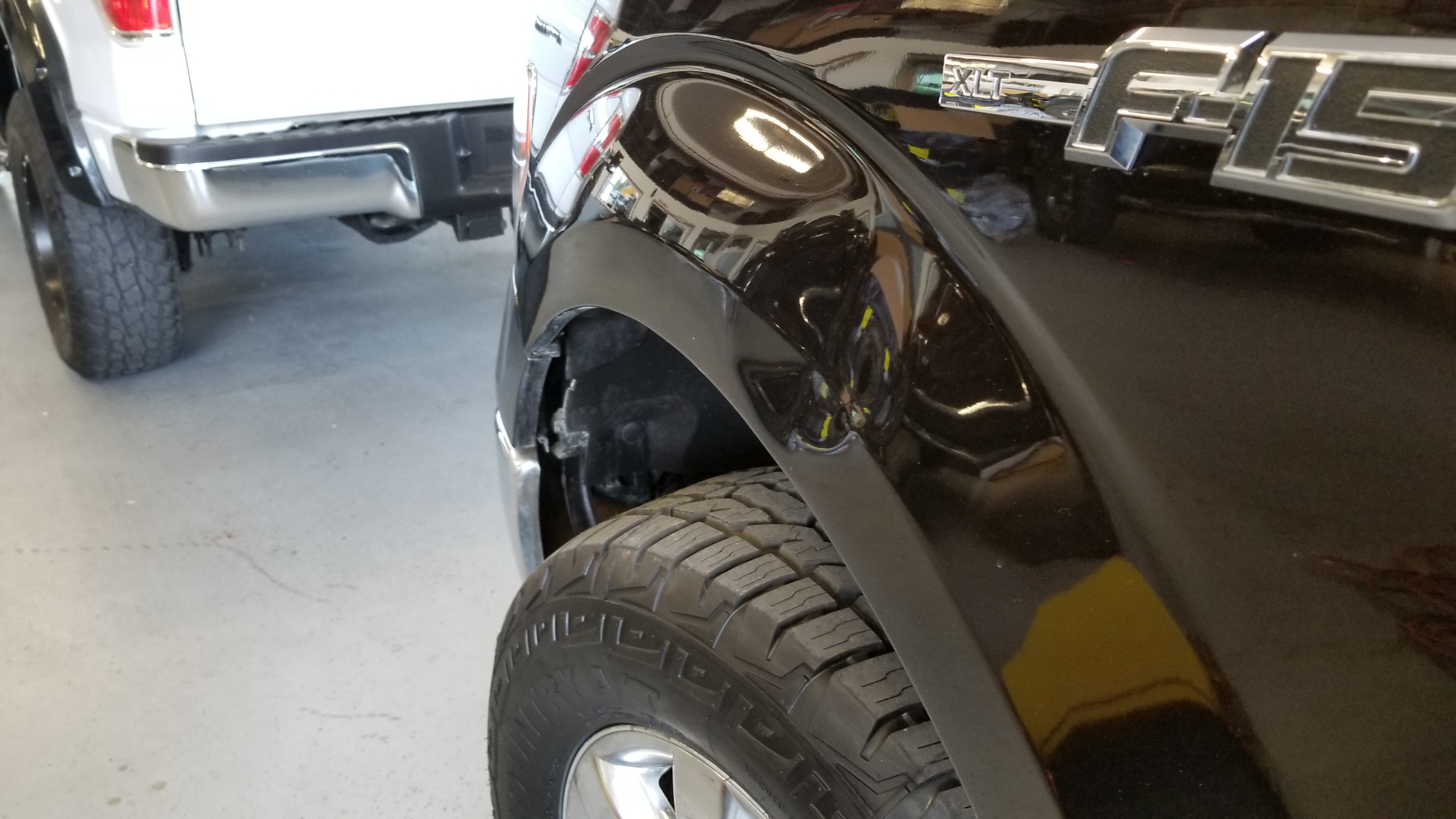 Black truck fender before paintless dent repair
