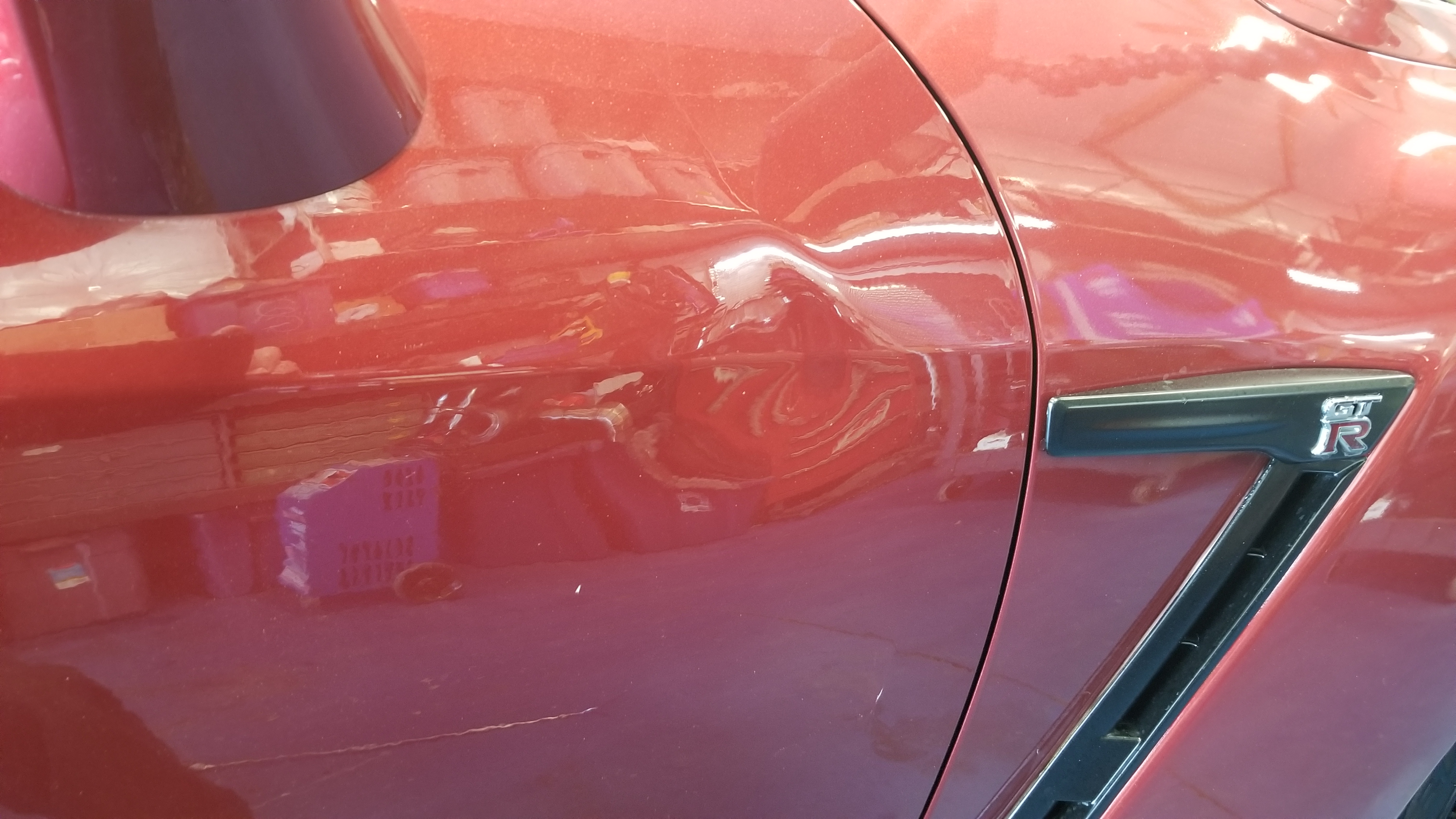 Red GT-R door before paintless dent repair