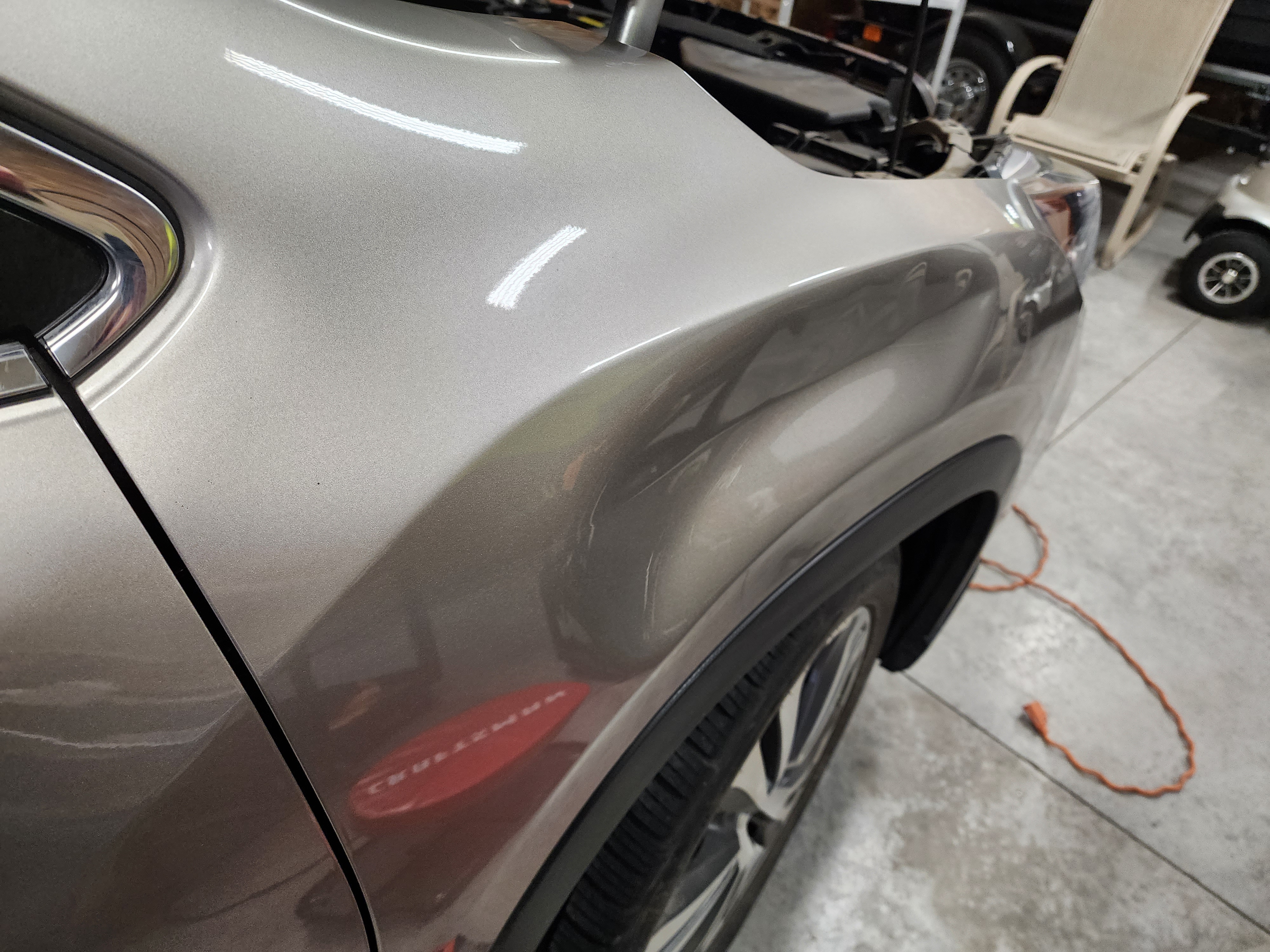 Tan front fender before paintless dent repair