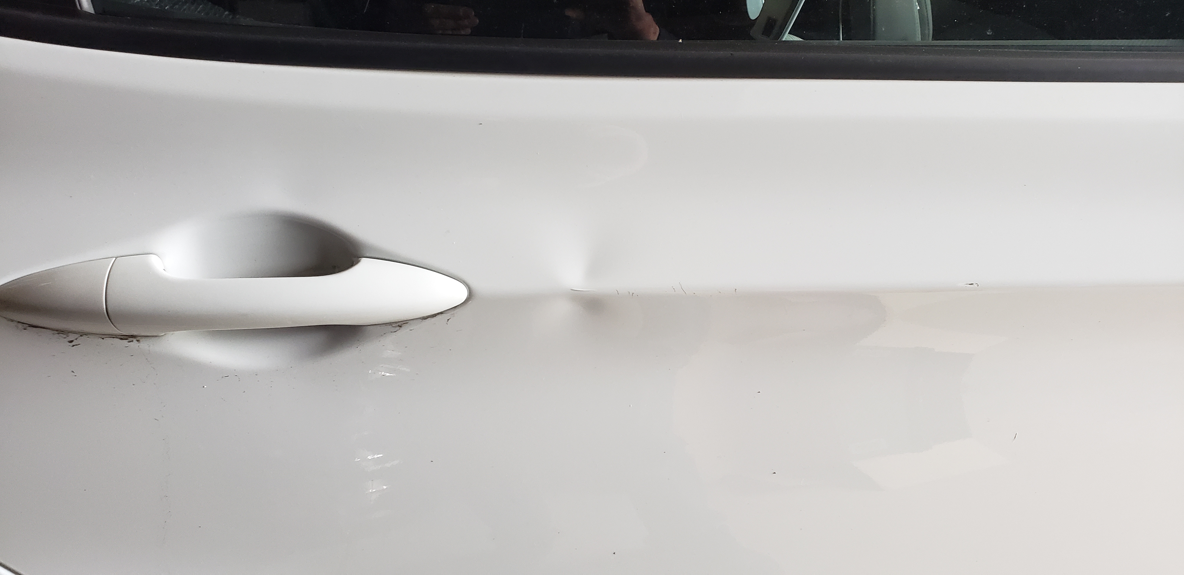 White door before paintless dent repair