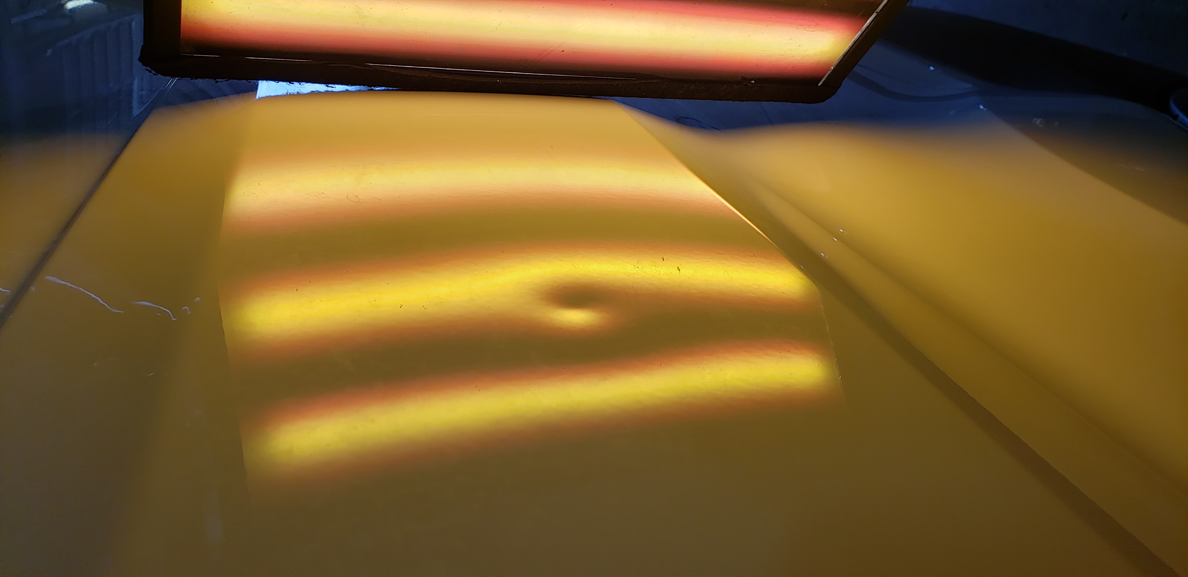 White truck quarter panel before paintless dent repair